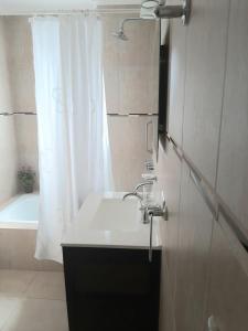 a bathroom with a sink and a tub and a shower at SanPier - Alquileres Temporarios in Allen