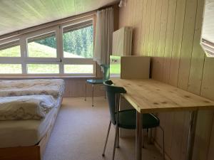 een kamer met een bed en een bureau en een bed en een bed en een raam bij Fewo 1 am Auweg in Hirschegg