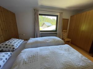 2 bedden in een slaapkamer met een raam bij Fewo 1 am Auweg in Hirschegg