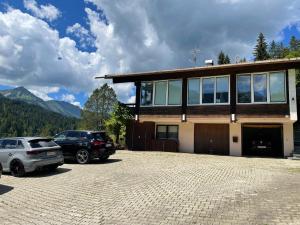 een huis met twee auto's geparkeerd op een parkeerplaats bij Fewo 1 am Auweg in Hirschegg