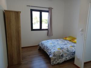 a bedroom with a bed and a window and a mirror at Ti CAZE RAMSA in Étang-Salé +11 photos
