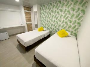 a room with two beds with yellow pillows at OCEANA HOTEL in San Andrés