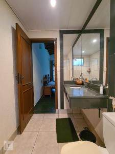 a large bathroom with a sink and a mirror at Hospedaria do Ernesto in Itanhandu