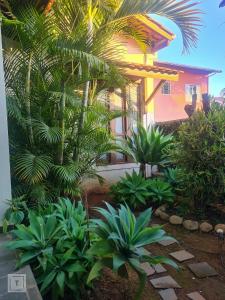 a garden in front of a house with palm trees at Hospedaria do Ernesto in Itanhandu