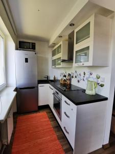  La cuisine est équipée de placards blancs et d'un réfrigérateur. dans l'établissement Kesklinna silla apartment, à Pärnu