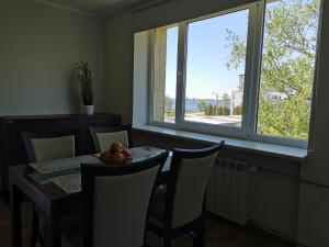 a dining room with a table and chairs and a window at Kesklinna silla apartment in Pärnu
