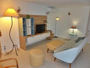 a living room with a couch and a tv at Rez de villa Aspretto Lazaret in Ajaccio