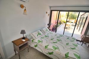 a bedroom with a bed and a table and a window at Rez de villa Aspretto Lazaret in Ajaccio