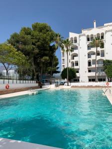 a swimming pool in front of a building at New & Beautiful Loft in Puerto Banus in Marbella