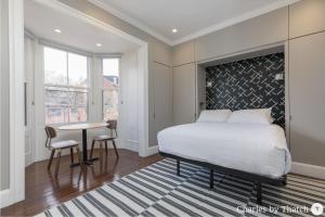 a bedroom with a bed and a table and a window at J Miller Flats by Thatch in Boston