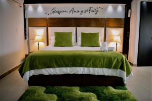 a bedroom with a large bed with a green blanket at Hotel Jade Spa in Santa Rosa de Cabal