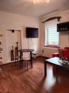 a living room with a table and a tv at Apartament Sielsko-Wiejsko in Szczytna