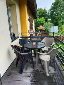 a patio with a table and chairs on a balcony at Apartament Sielsko-Wiejsko in Szczytna