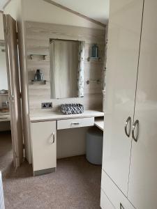 a bathroom with a white desk and a mirror at Heron 41, Scratby - California Cliffs, Parkdean, sleeps 6, pet friendly, bed linen and towels included - close to the beach in Scratby