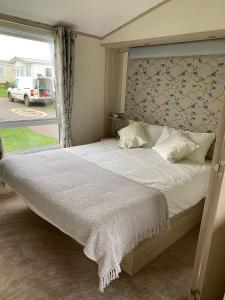 ScratbyにあるHeron 41, Scratby - California Cliffs, Parkdean, sleeps 6, pet friendly, bed linen and towels included - close to the beachのベッドルーム(大きな白いベッド1台、窓付)