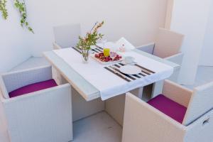 a white table topped with a white vase filled with flowers at AB Apartamentos Museum in Málaga