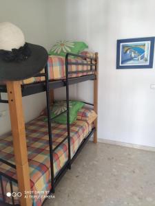 2 stapelbedden in een kamer met een hoed bij Precioso Atico a pie de playa con piscina. in Motril