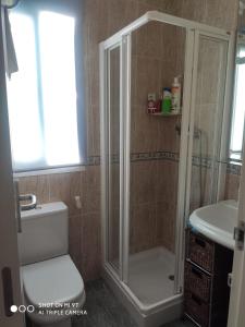 een badkamer met een douche, een toilet en een wastafel bij Precioso Atico a pie de playa con piscina. in Motril