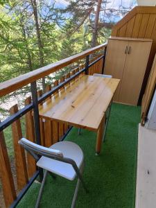 una mesa de madera y una silla en el balcón en Studio 4 couchages, en Auron