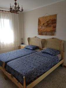 a bedroom with two beds with blue sheets and a window at Apartamento en la torre de S`Abanell in Blanes