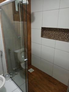 uma casa de banho com um chuveiro e um WC. em Hotel Oiticica em Fortaleza