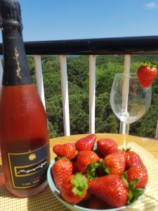 a plate of strawberries next to a bottle of wine at Apartamento en la torre de S`Abanell in Blanes