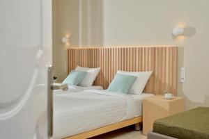 a bedroom with a large bed with blue pillows at Alykanas Beach Grand Hotel by Zante Plaza in Alikanas