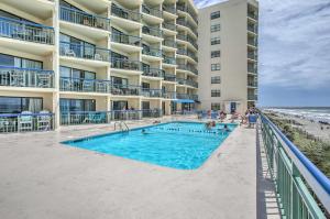 a swimming pool in front of a building and the beach at North Myrtle Beach Oceanfront Condo with Pool! in Myrtle Beach