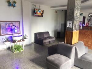 una sala de espera con 2 sillas y TV en Germano's Hotel, en Jequié