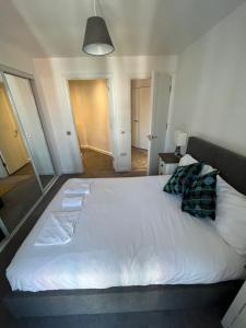 a large white bed with two pillows on it at City Centre Luxury Apartments in Belfast