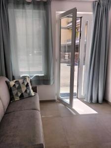 ein Wohnzimmer mit einem Sofa und einer Glasschiebetür in der Unterkunft Giù da Nonna in Gaeta