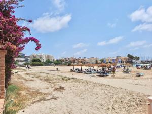 Plaża z grupą ludzi siedzących na piasku w obiekcie Sinforosa Park Apartments w mieście Torrevieja