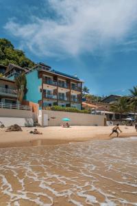 a person running on a beach with an umbrella at Pousada Dona Moça in Morro de São Paulo