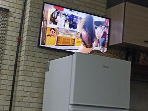 a tv on top of a refrigerator in a kitchen at Частный дом Ленкорань in Lankaran
