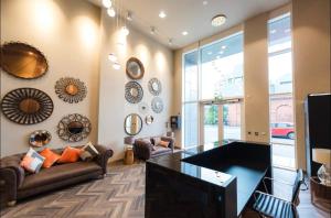 uma sala de estar com um sofá e uma mesa de vidro em City Centre Luxury Apartments em Belfast