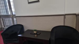uma sala de reuniões com duas cadeiras e uma mesa em Midlands Hotel em Mansfield