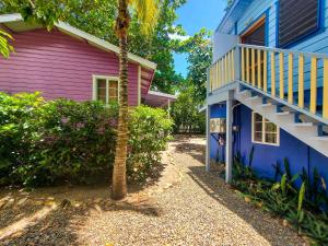 a pink and blue house with a staircase at Placencia Villas in Placencia