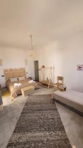 a living room with two beds and a rug at Riad Nohad Marrakech Villa Privatisée in Oulad Boudene