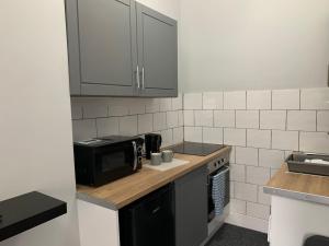 a kitchen with a microwave oven and a stove at Nelson st (VIEWPARK) in Largs
