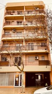 un bâtiment avec des balcons et un arbre en face de celui-ci dans l'établissement Departamento Céntrico SJ Boutique, à San Juan