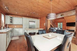 a kitchen and dining room with a table and chairs at Chalet Bonheur -Rustique- Pet friendly in Rivière-Rouge