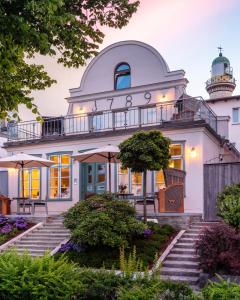 uma casa com um farol em cima dela em Kapitaenshaus in Wasserlage! Traumapartments Warnemuende em Warnemünde