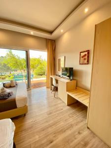 1 dormitorio con 1 cama y escritorio con ordenador en Sunny Place Resort Kilada, en Kilada
