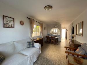 uma sala de estar com um sofá branco e uma mesa em Garden Apartment, La Noria em Málaga