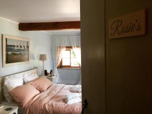 a bedroom with a bed with pink sheets and a window at Lut's Place in Lincoln