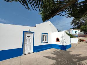 un edificio bianco e blu con una porta di Monte da Vinha Nova a Santiago do Cacém