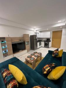 sala de estar con sofá azul y almohadas amarillas en PALACE B Av Hassan II Marrakech 40000 -Brand New Luxury UNIT#2 & UNIT#29, en Marrakech