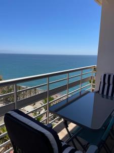 a balcony with a table and chairs and the ocean at La Roca Sea View Apartment in Torremolinos