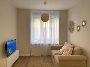 sala de estar con sofá y TV en Precioso apartamento junto a Casco Viejo, en Bilbao