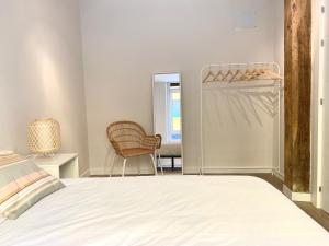 1 dormitorio con cama, silla y espejo en Precioso apartamento junto a Casco Viejo en Bilbao